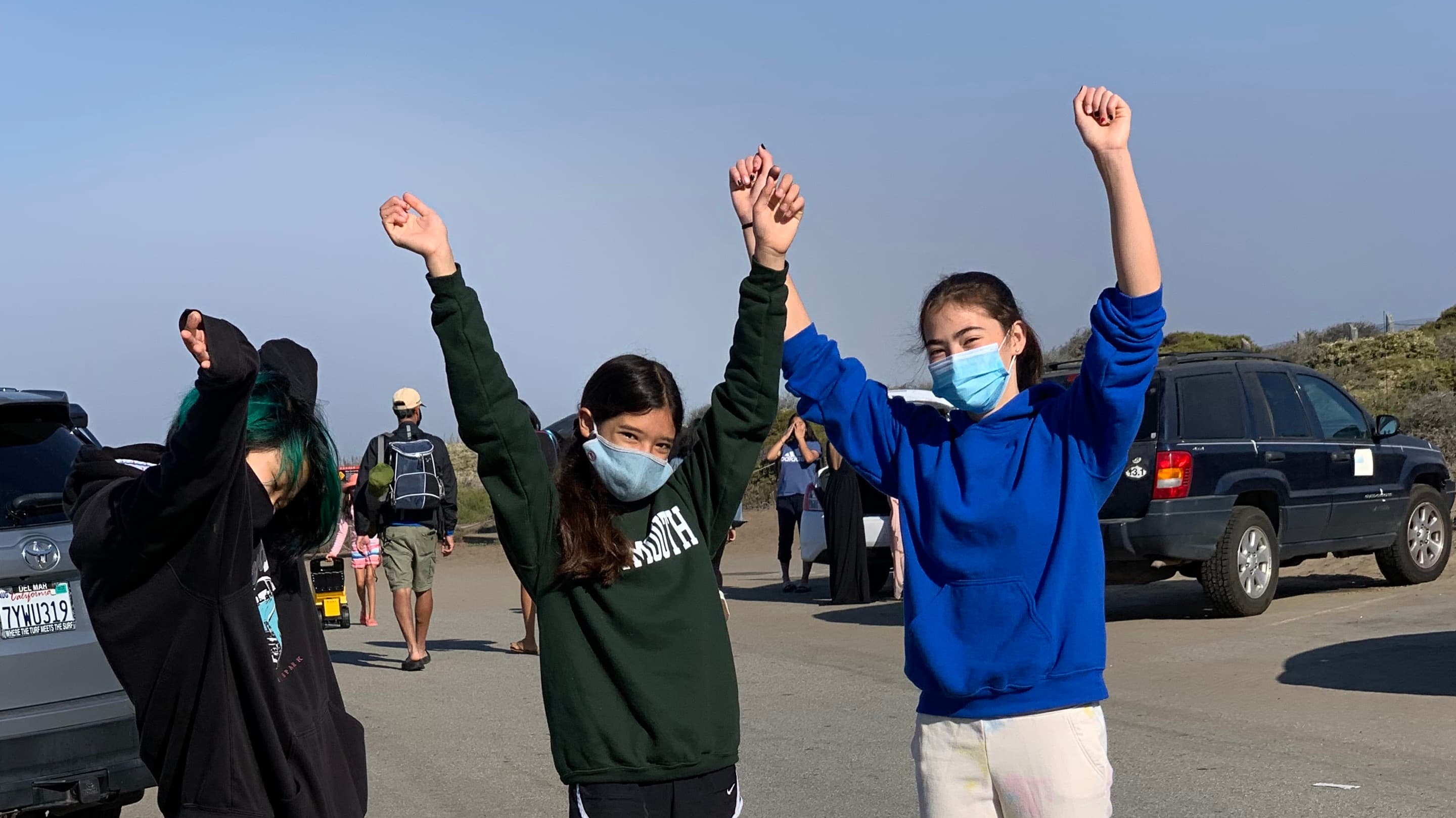Sophia Tabibian, Lulu Goulet-Hofsass and a Covalence team member after a beach clean up. They wear blue medical masks and hoodies. 