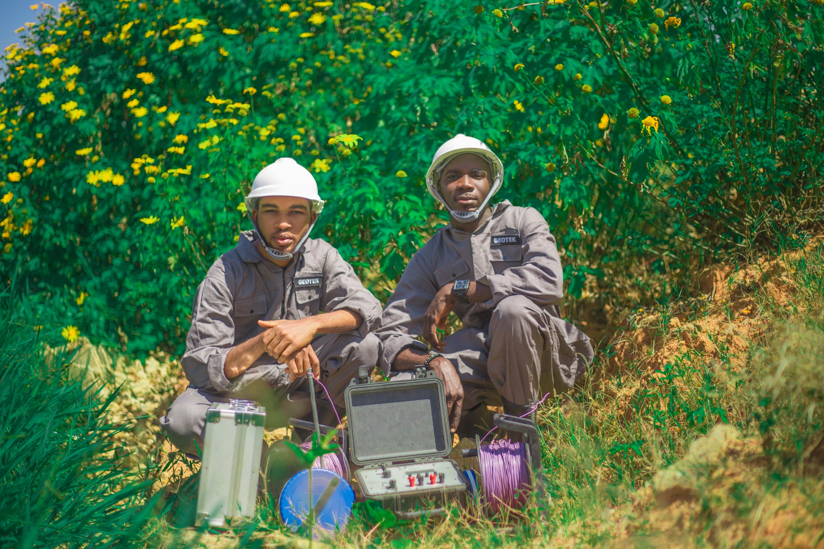 Two members of the GeoTek team next to an installed water quality monitor.