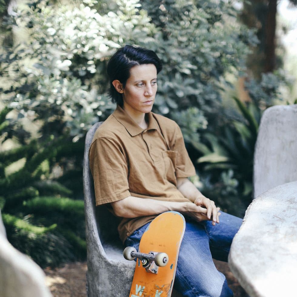 Alexis Sablone sitting with their skateboard