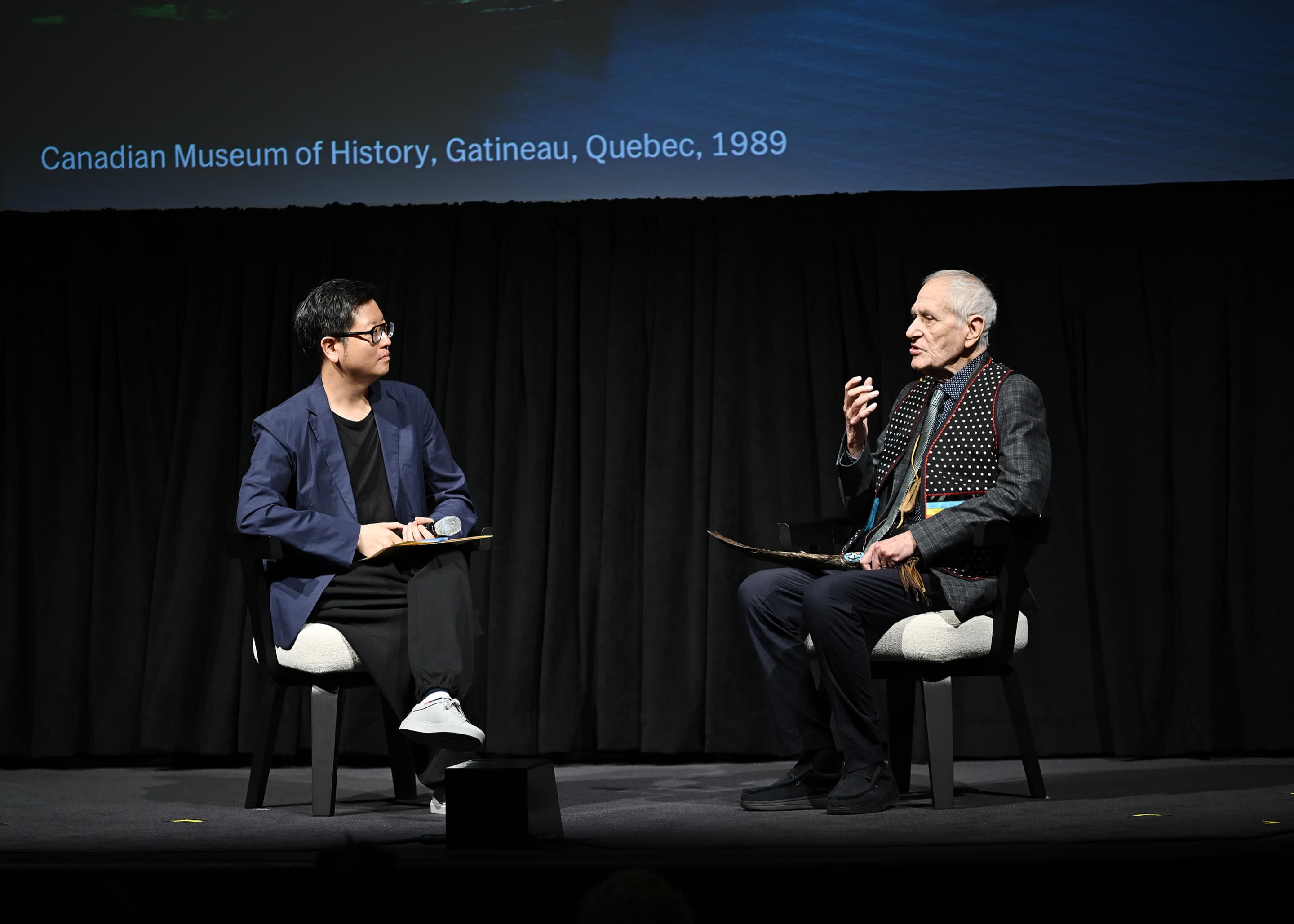 Carson Chan and Douglas Cardinal on stage at MoMA.