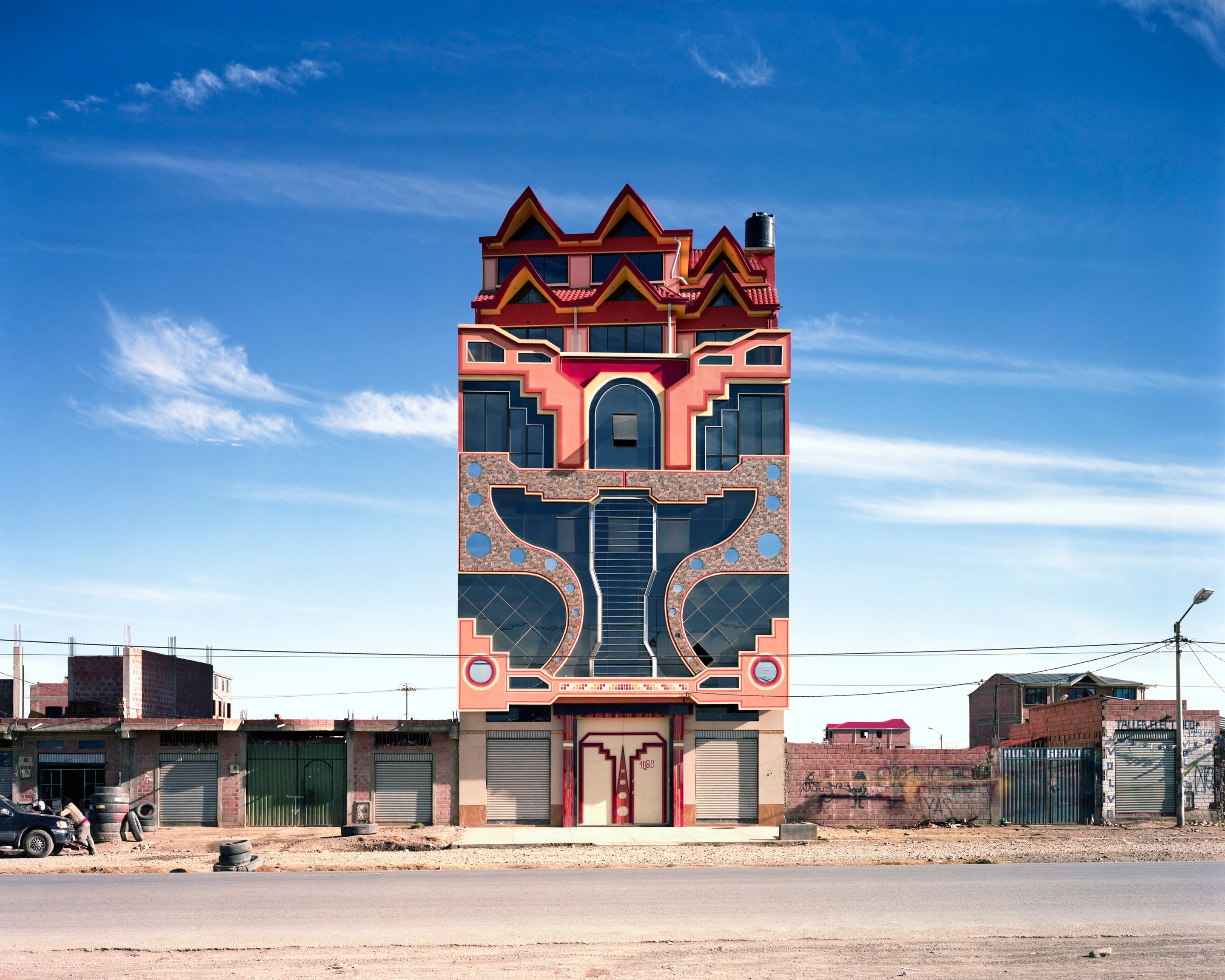 El Gallo de Oro, Villa Mercedes in El Alto, Bolivia. The building's bold facades use bright colours and geometric patterns.