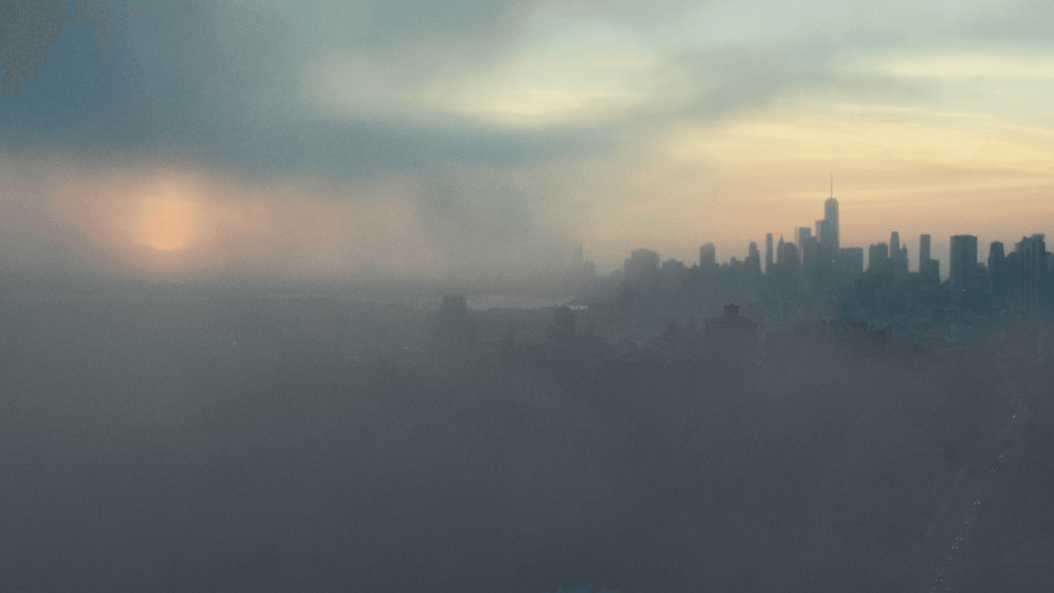 A grey haze drifts toward a distant city at sunset in a still from The First Wave by Matthew Heineman