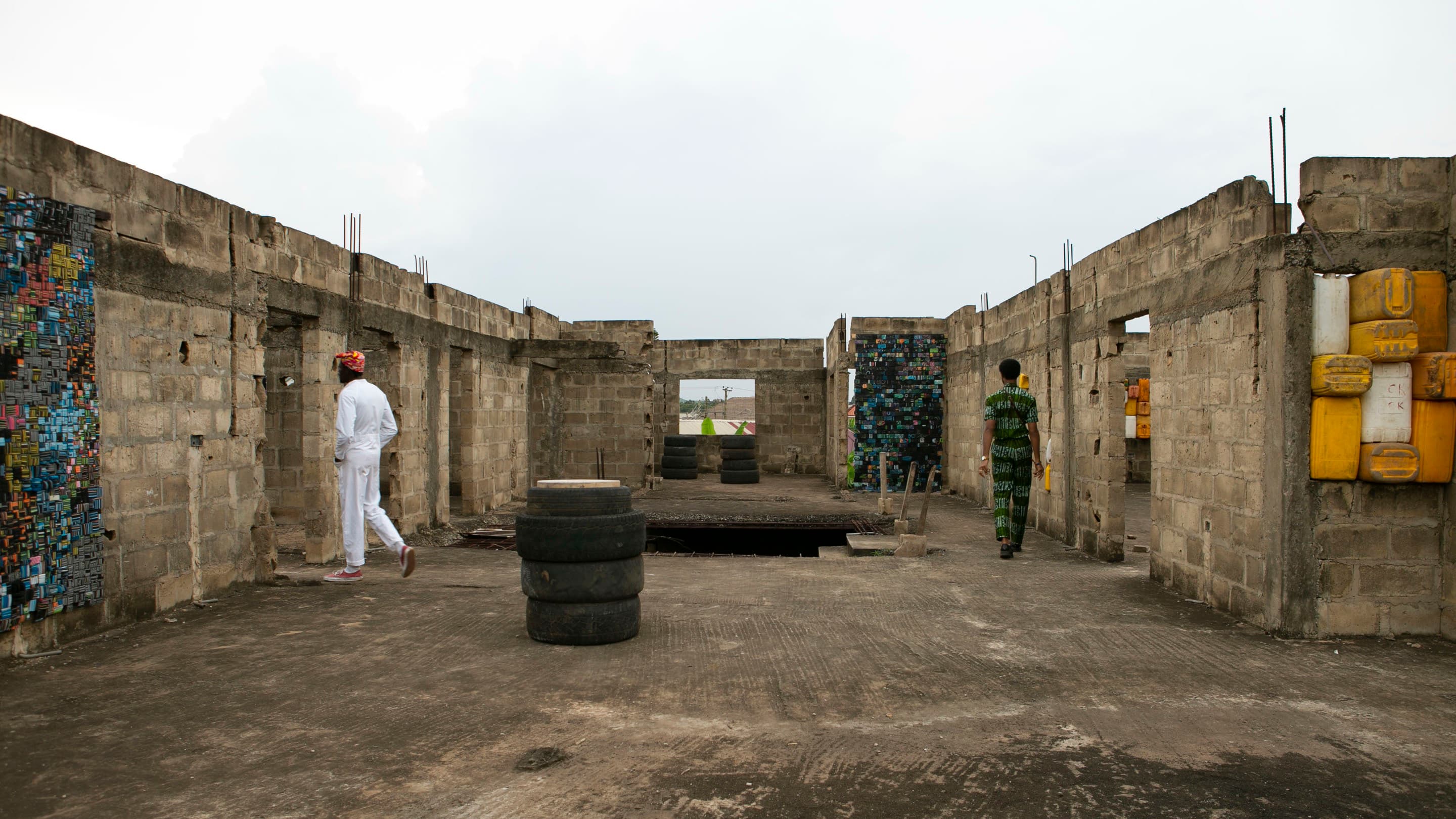 People walk through art activation in an unfinished concrete block building.